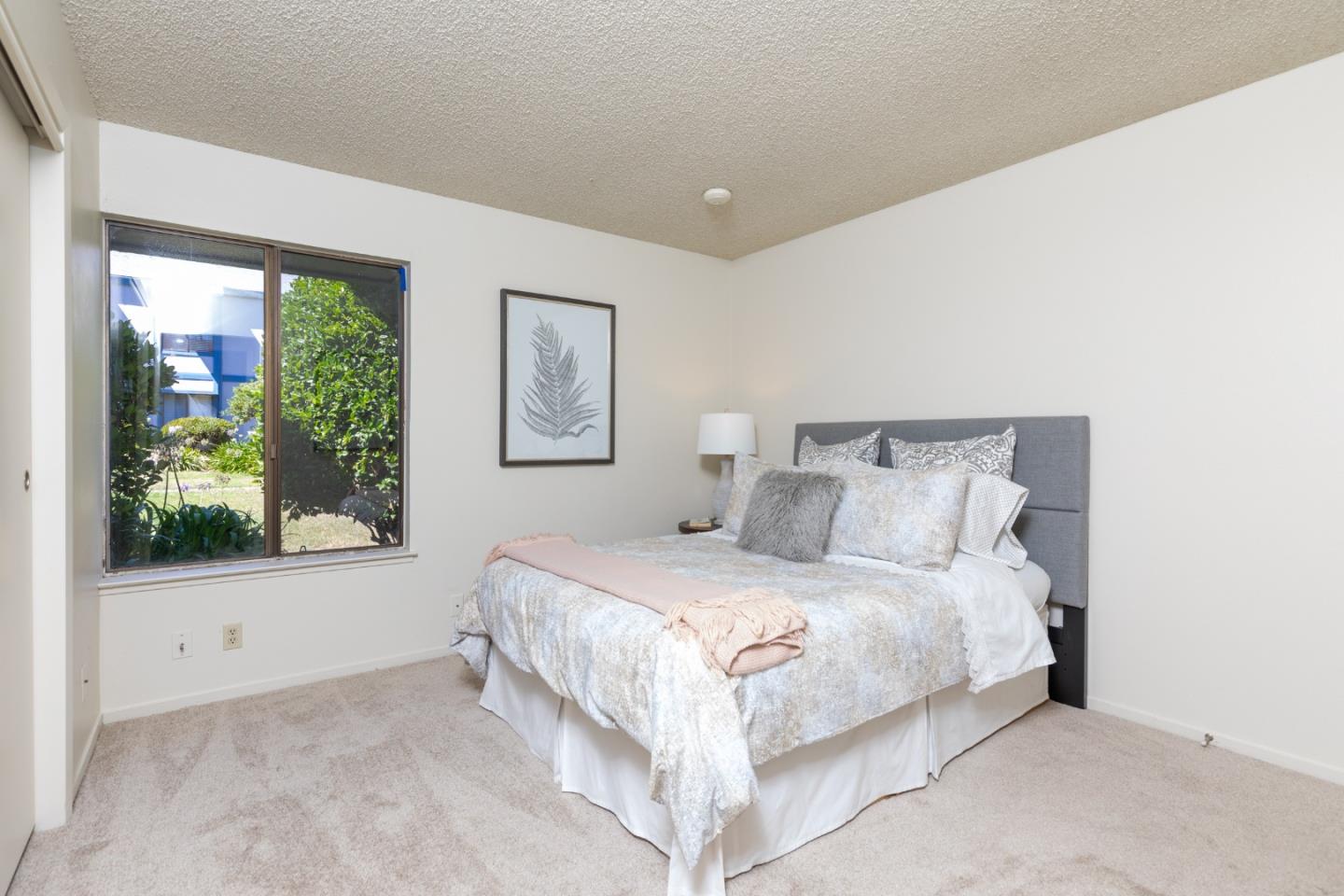 1925 46th Avenue, Unit 105 Capitola, CA 95010 - Photo 13 of 27 a bedroom with a bed and a window