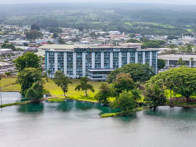 an aerial view of a house with a garden and lake view