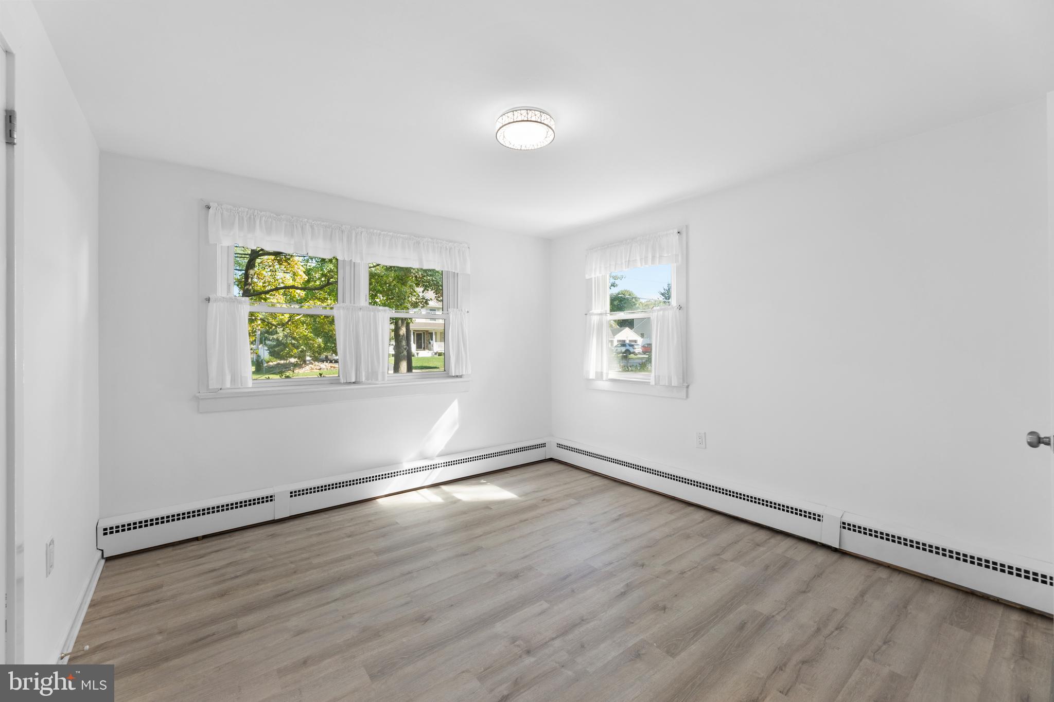 245 Paxson Avenue Hamilton, NJ 08690 - Photo 11 of 26 an empty room with wooden floor and windows