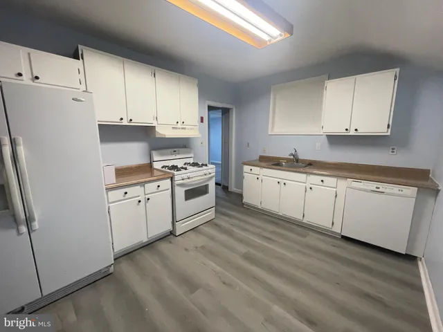 a kitchen with white cabinets and white appliances