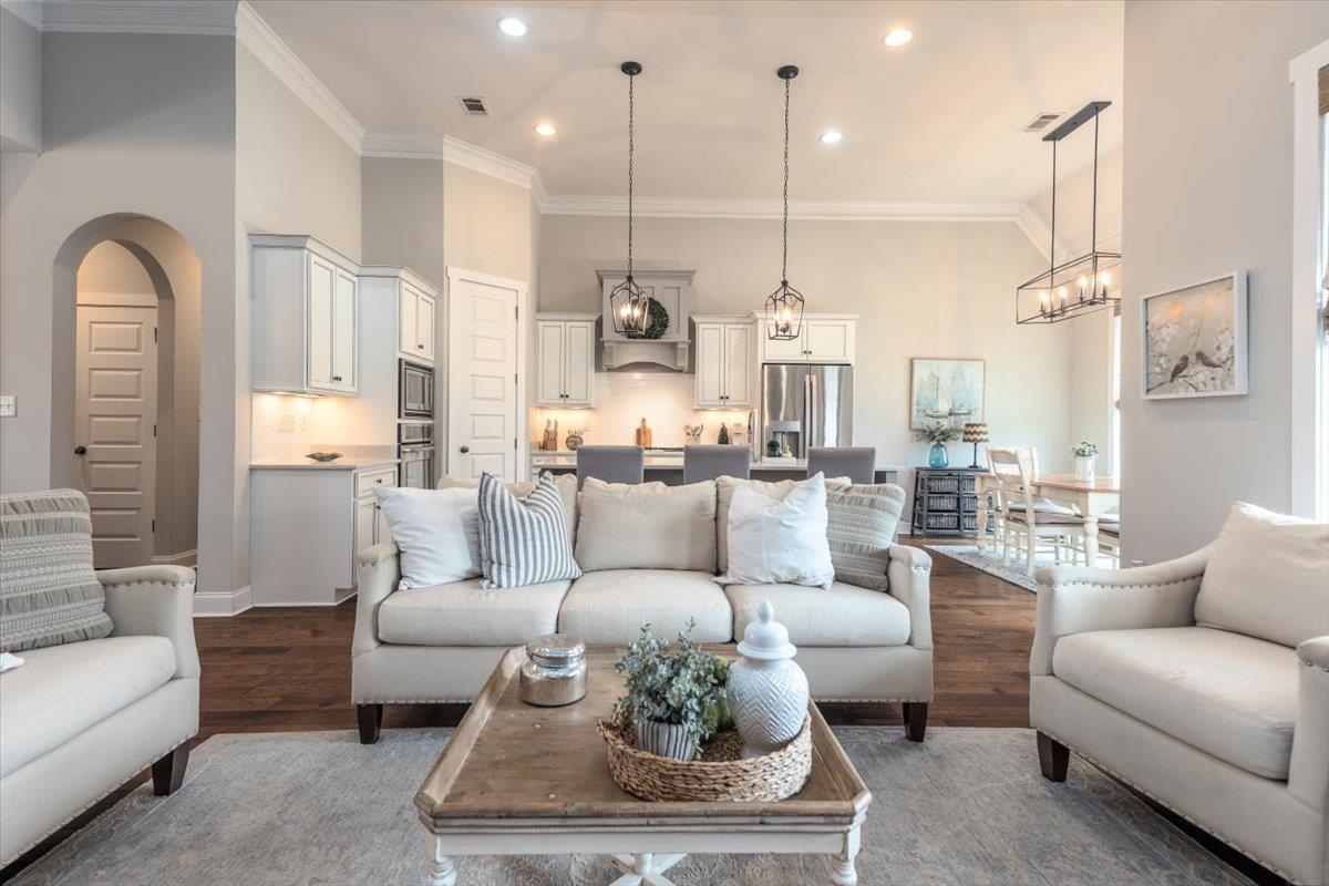 608 Cypress Run Cove Collierville, TN 38017 - Photo 6 of 40 Living room with a high ceiling, wood finished floors, crown molding, arched walkways, and suspended lighting