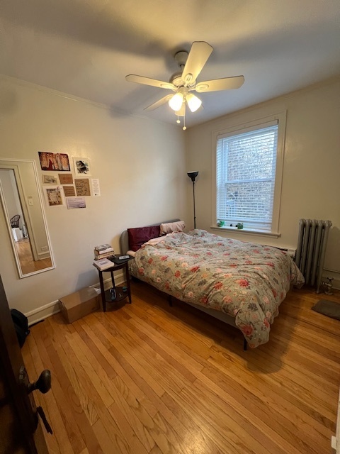 4224 North Clark Street, Unit 3 Chicago, IL 60613 - Photo 12 of 15 a bedroom with a bed and a chandelier
