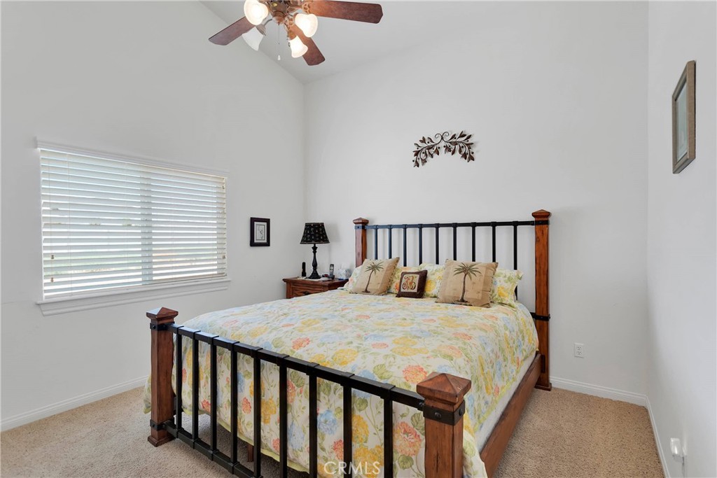 17367 Central Road Apple Valley, CA 92307 - Photo 35 of 61 a bedroom with a bed and a chandelier