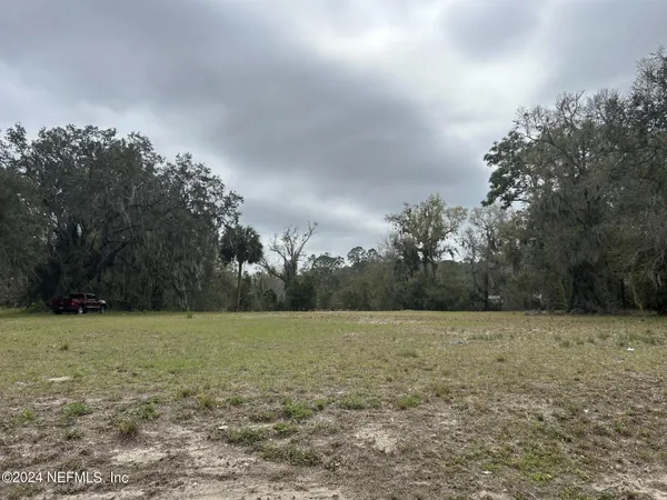 a view of a field with trees in background