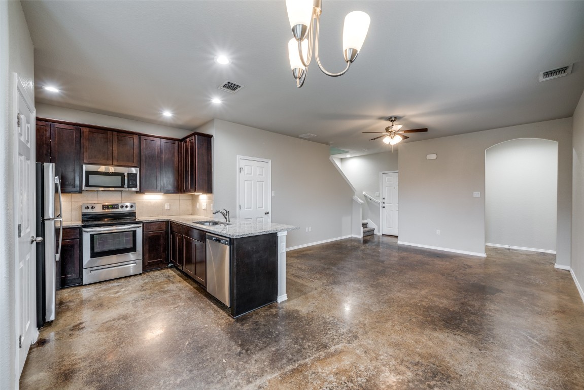 1502 Lucille Street Seguin, TX 78155 - Photo 4 of 13 a kitchen with stainless steel appliances granite countertop a refrigerator a stove a sink and a microwave