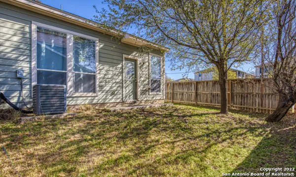 a view of house with backyard and a tree