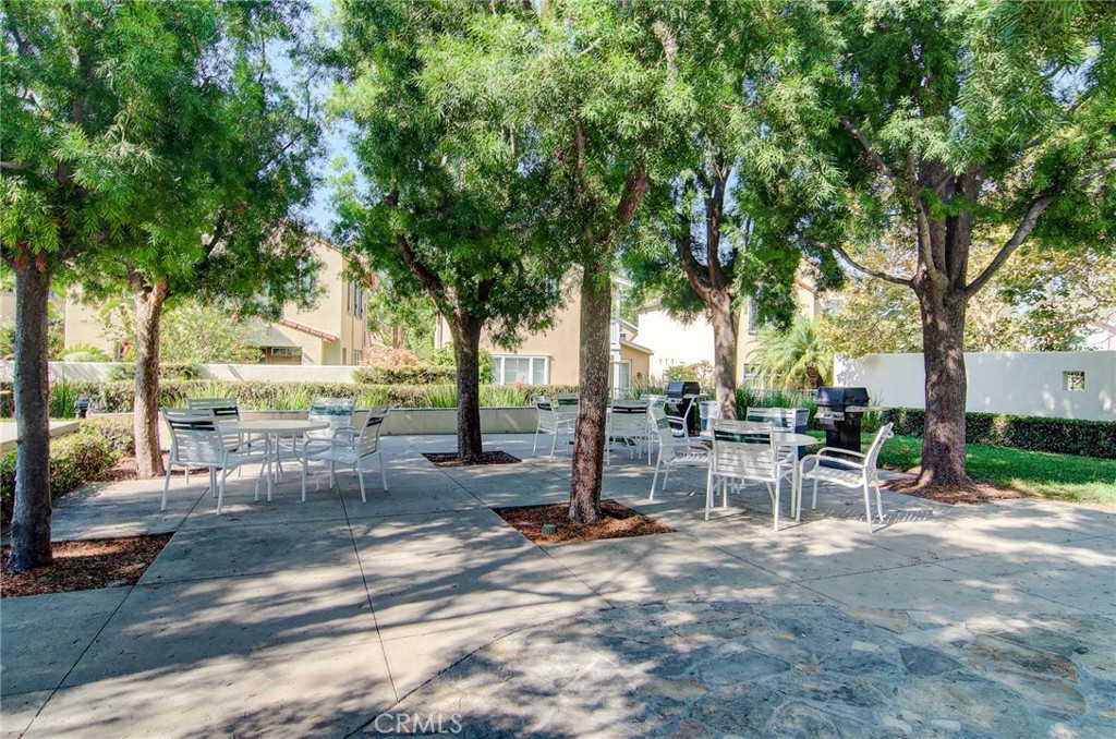 13069 Arborwalk Lane Tustin, CA 92782 - Photo 43 of 47 a view of a backyard with table and chairs and potted plants