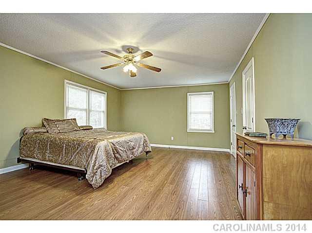 2132 Dunlap Roddey Road Rock Hill, SC 29730 - Photo 9 of 16 a spacious bedroom with a bed and a chandelier