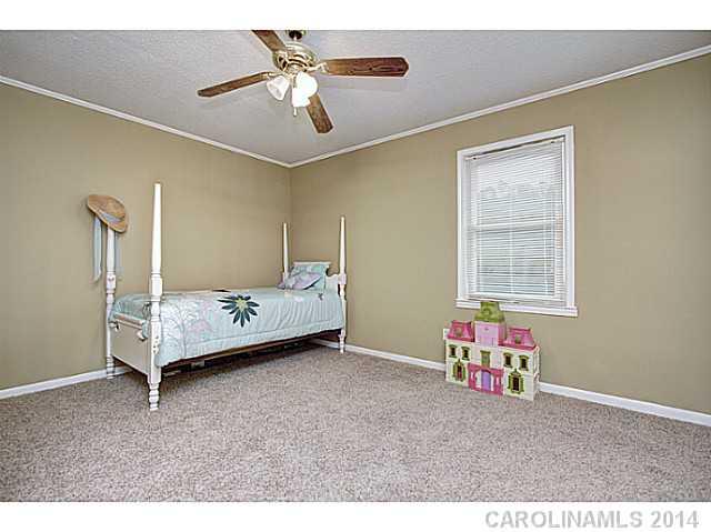 2132 Dunlap Roddey Road Rock Hill, SC 29730 - Photo 10 of 16 a bedroom with a bed and a chandelier