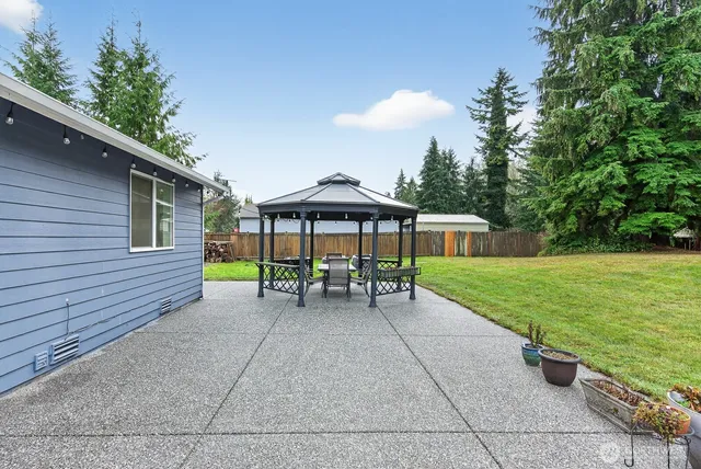 a view of a house with backyard and a sitting area