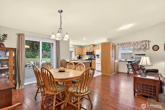 a dining room with furniture wooden floor and a chandelier