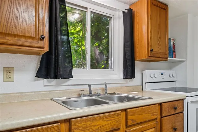 a kitchen with sink a window and cabinets