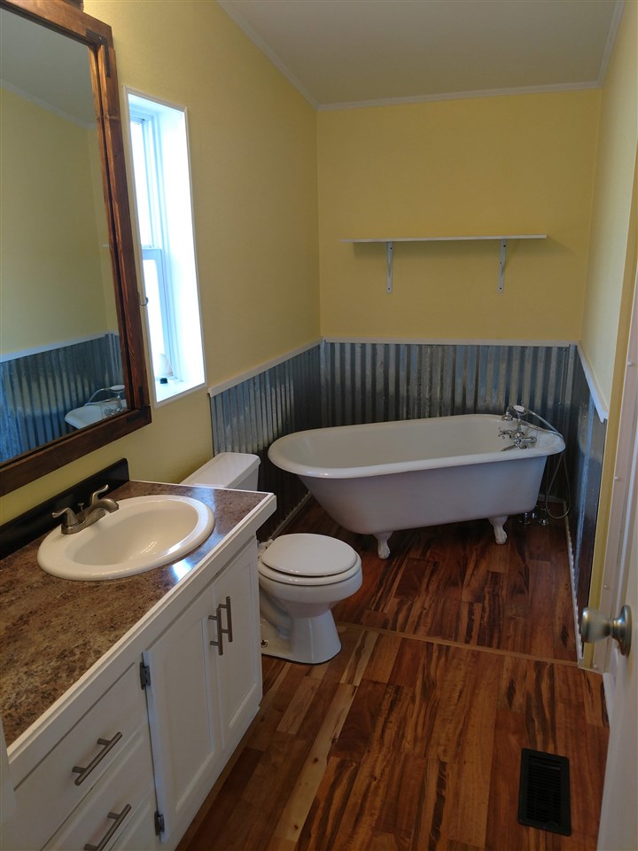 19776 Ward Creek Road Cedaredge, CO 81413 - Photo 16 of 25 a bathroom with a granite countertop sink vanity mirror and toilet