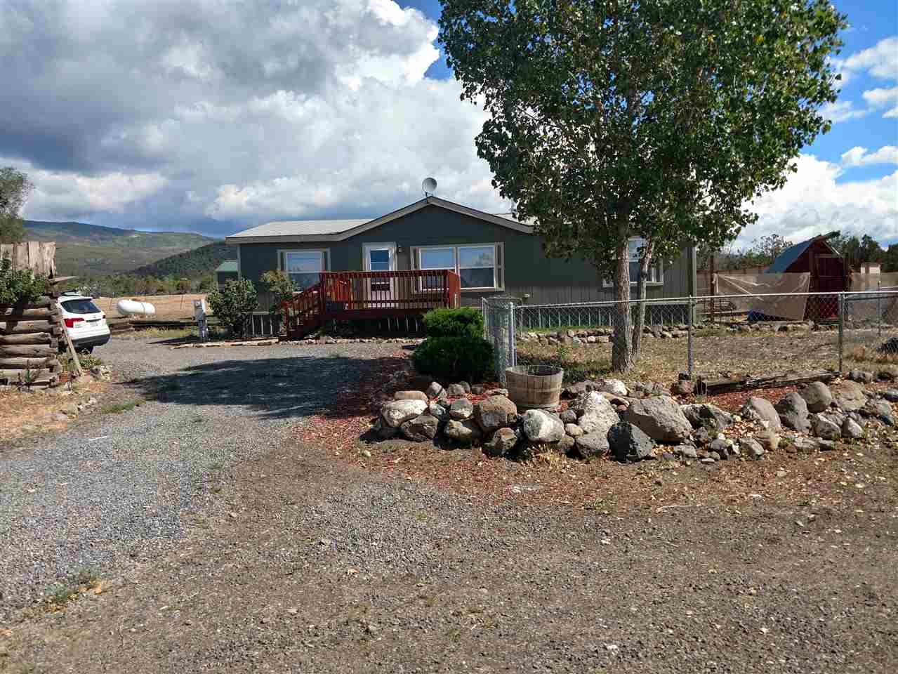 19776 Ward Creek Road Cedaredge, CO 81413 - Photo 2 of 25 a backyard of a house with table and chairs