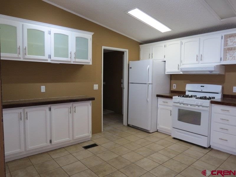 19776 Ward Creek Road Cedaredge, CO 81413 - Photo 3 of 25 a kitchen with a stove refrigerator and cabinets