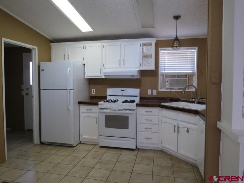 19776 Ward Creek Road Cedaredge, CO 81413 - Photo 4 of 25 a kitchen with white cabinets and white appliances