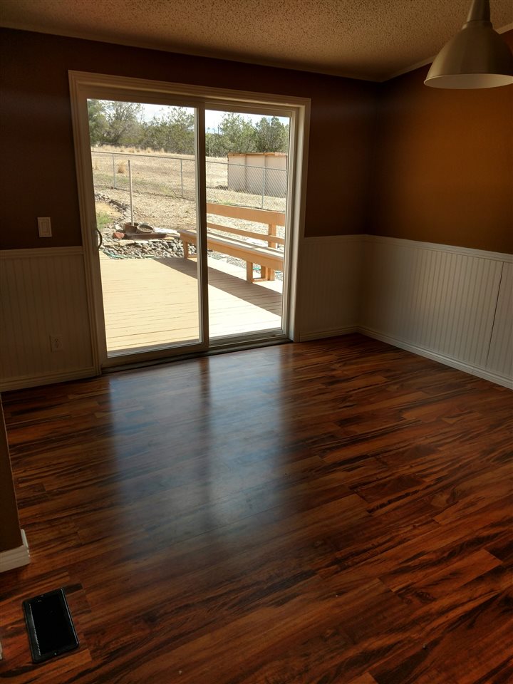 19776 Ward Creek Road Cedaredge, CO 81413 - Photo 5 of 25 a view of an empty room with wooden floor and a window