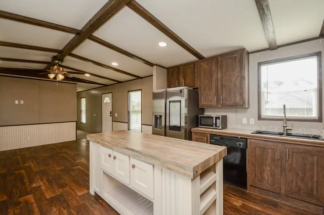 a kitchen with stainless steel appliances granite countertop a sink a stove and a refrigerator