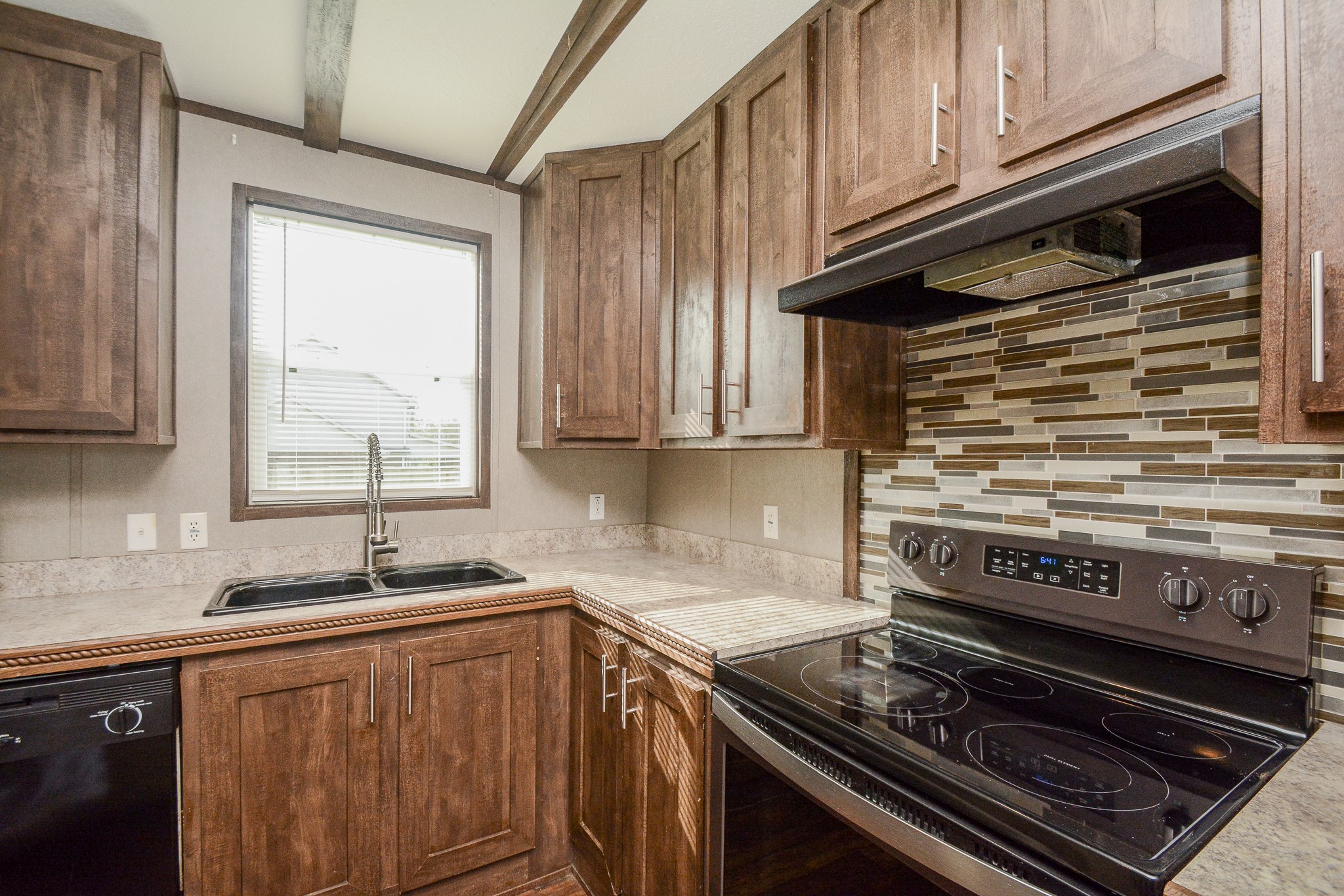 3610 Alice Street Fresno, TX 77545 - Photo 9 of 26 a kitchen with wooden cabinets and a stove top oven