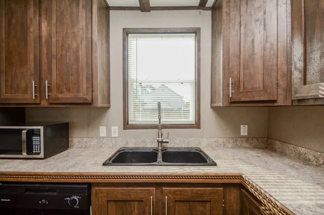 a kitchen with stainless steel appliances granite countertop white cabinets and a sink