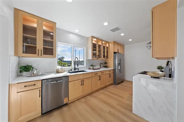 a kitchen with white cabinets and sink