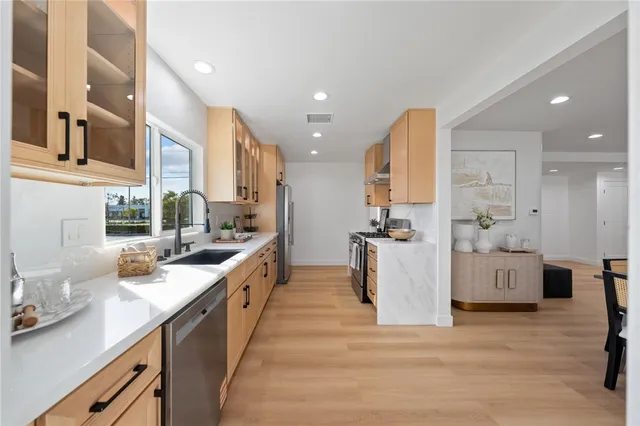 a large kitchen with stainless steel appliances lots of counter space and windows