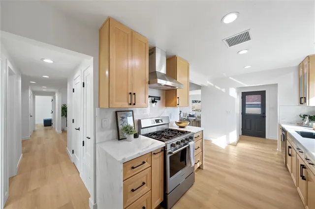a kitchen with stainless steel appliances a stove a sink a refrigerator and cabinets