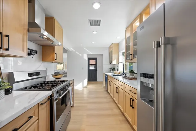 a kitchen with stainless steel appliances a sink and a stove