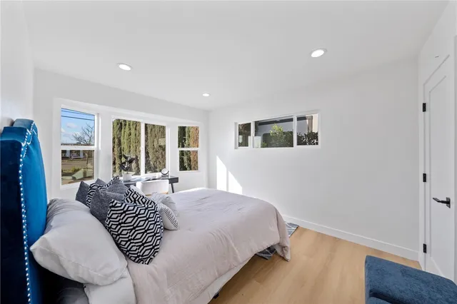 a large bedroom with a bed and wooden floor