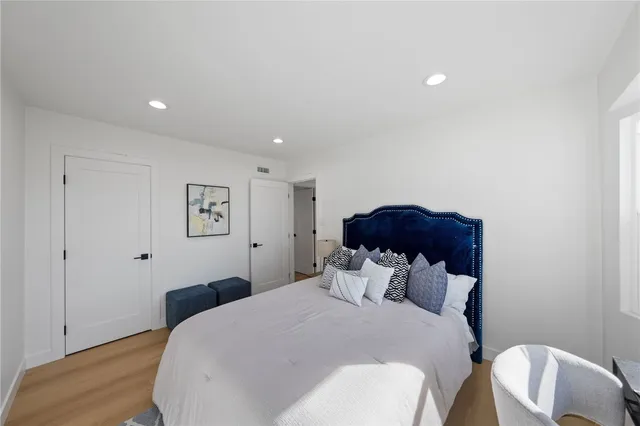 a bedroom with a bed and a painting on the wall