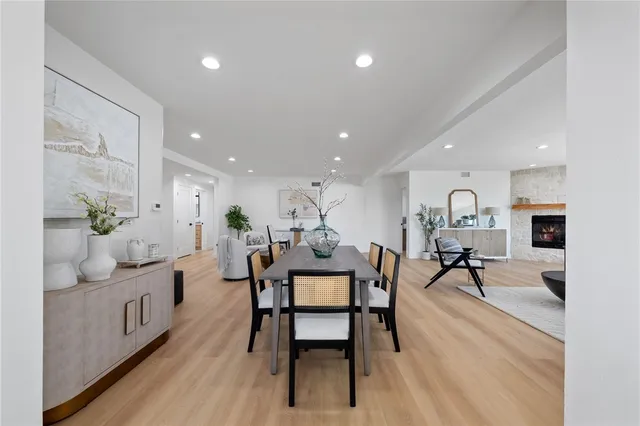 a dining room with furniture potted plants and wooden floor