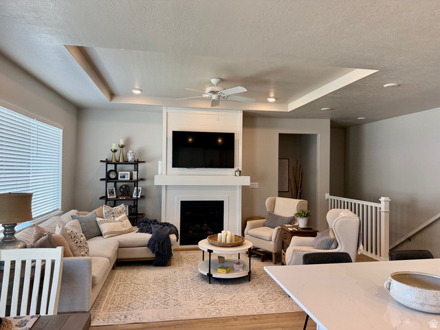 315 South Sherman Street Mapleton, UT 84664 - Photo 5 of 30 Living area featuring a fireplace with a white mantel, recessed lighting, ceiling fan, wood-finish flooring, and a tray ceiling