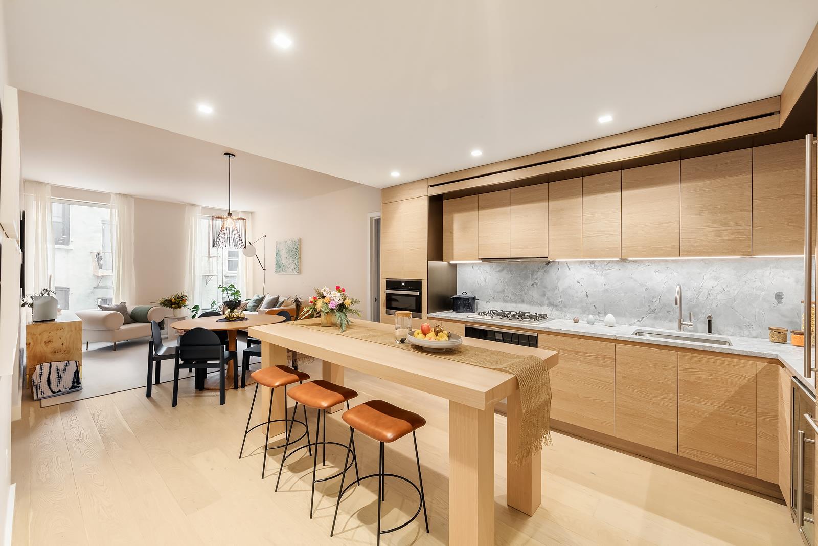 215 West 28th Street, Unit 2C Manhattan, NY 10001 - Photo 1 of 17 a kitchen with a table chairs stove and cabinets