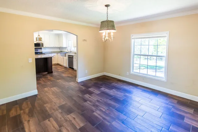 a view of a kitchen with a sink stove cabinets and empty room