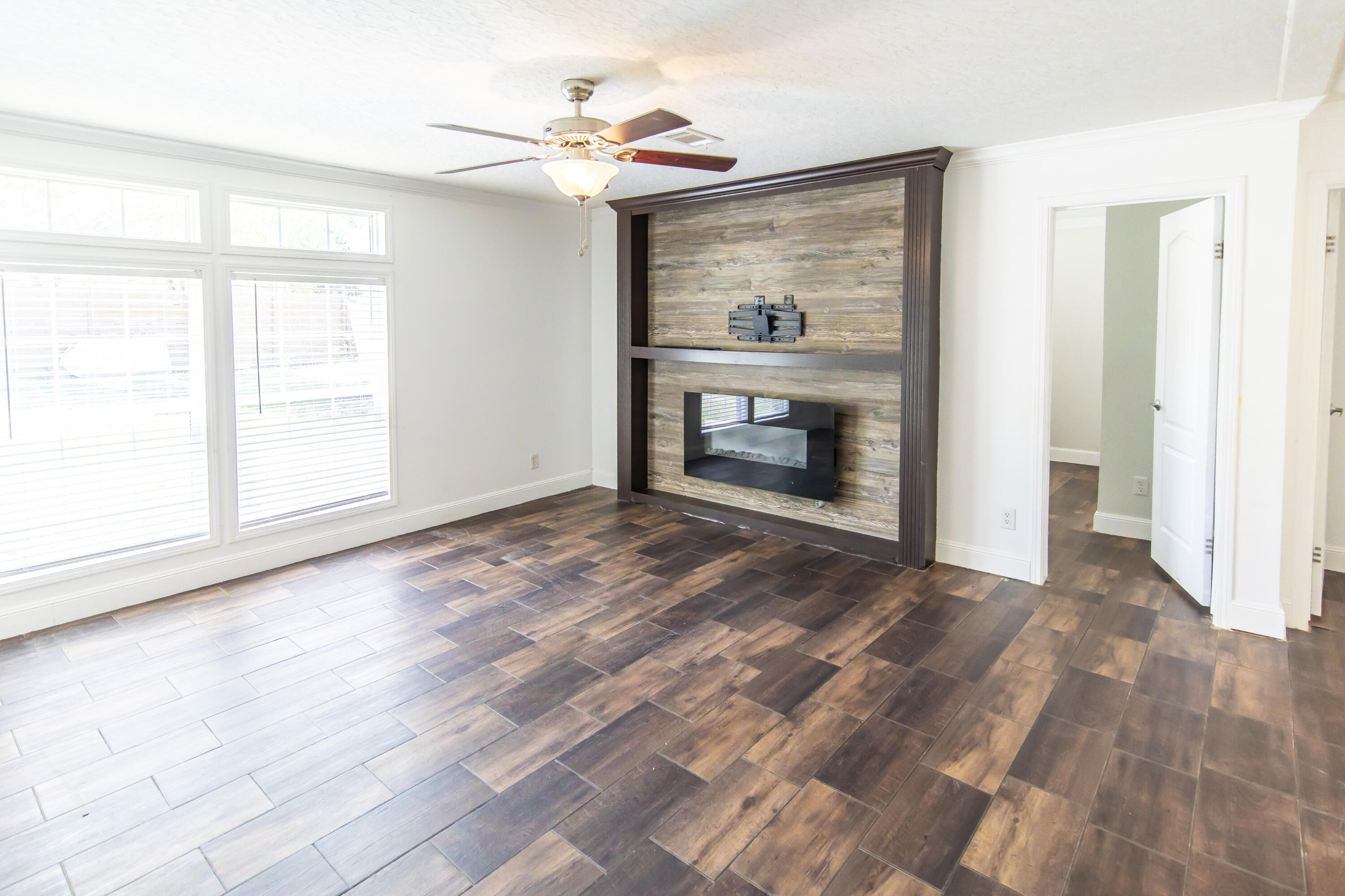 748 Phillips Drive Freeport, FL 32439 - Photo 19 of 50 a view of empty room with wooden floor fireplace and a window