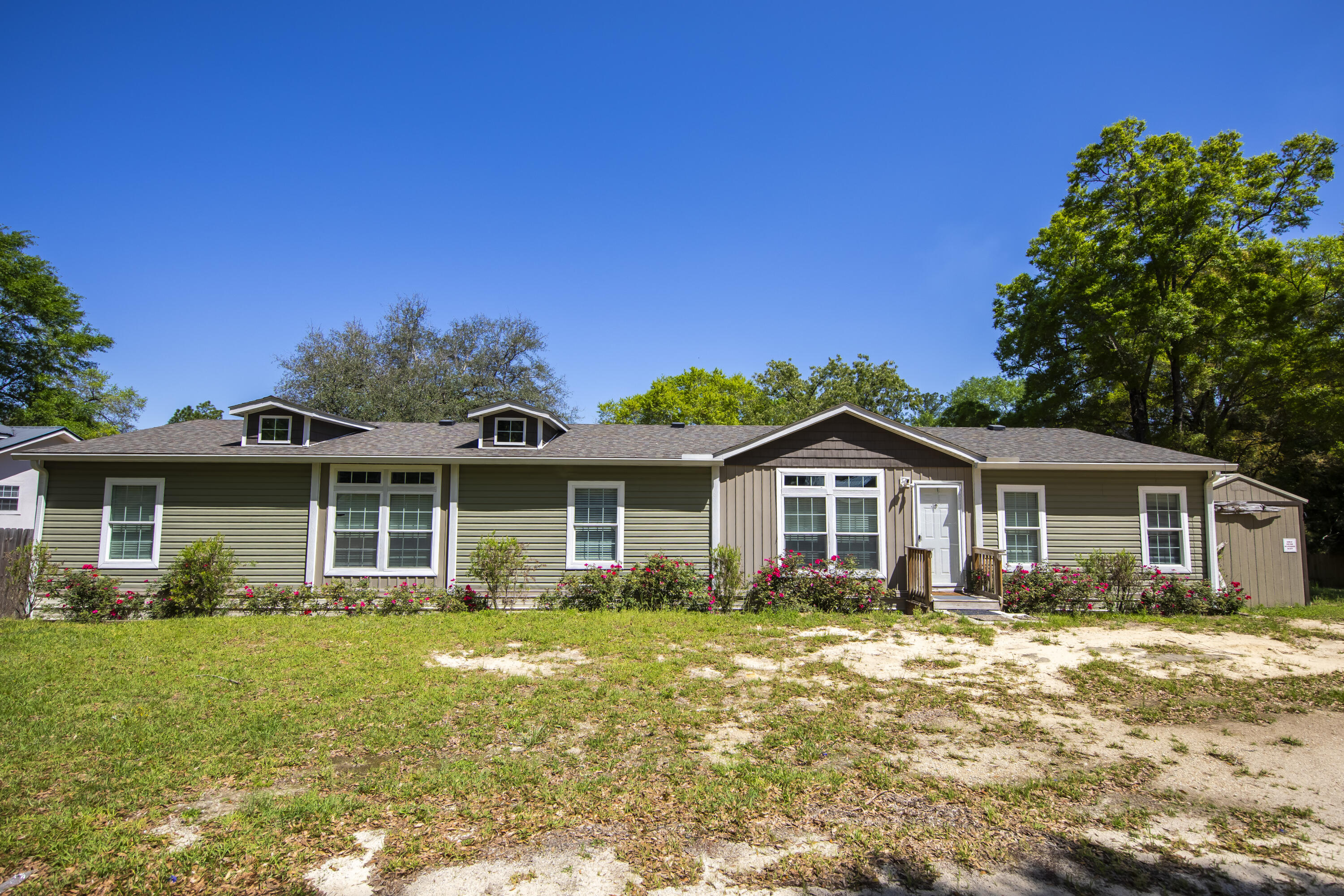 748 Phillips Drive Freeport, FL 32439 - Photo 2 of 50 a front view of a house with a garden