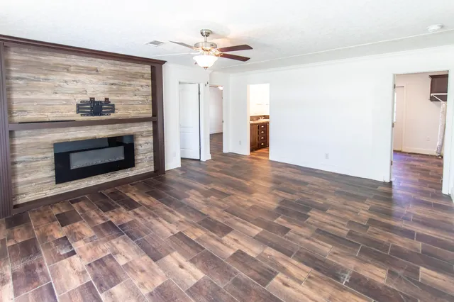 a view of empty room with a fireplace and wooden floor