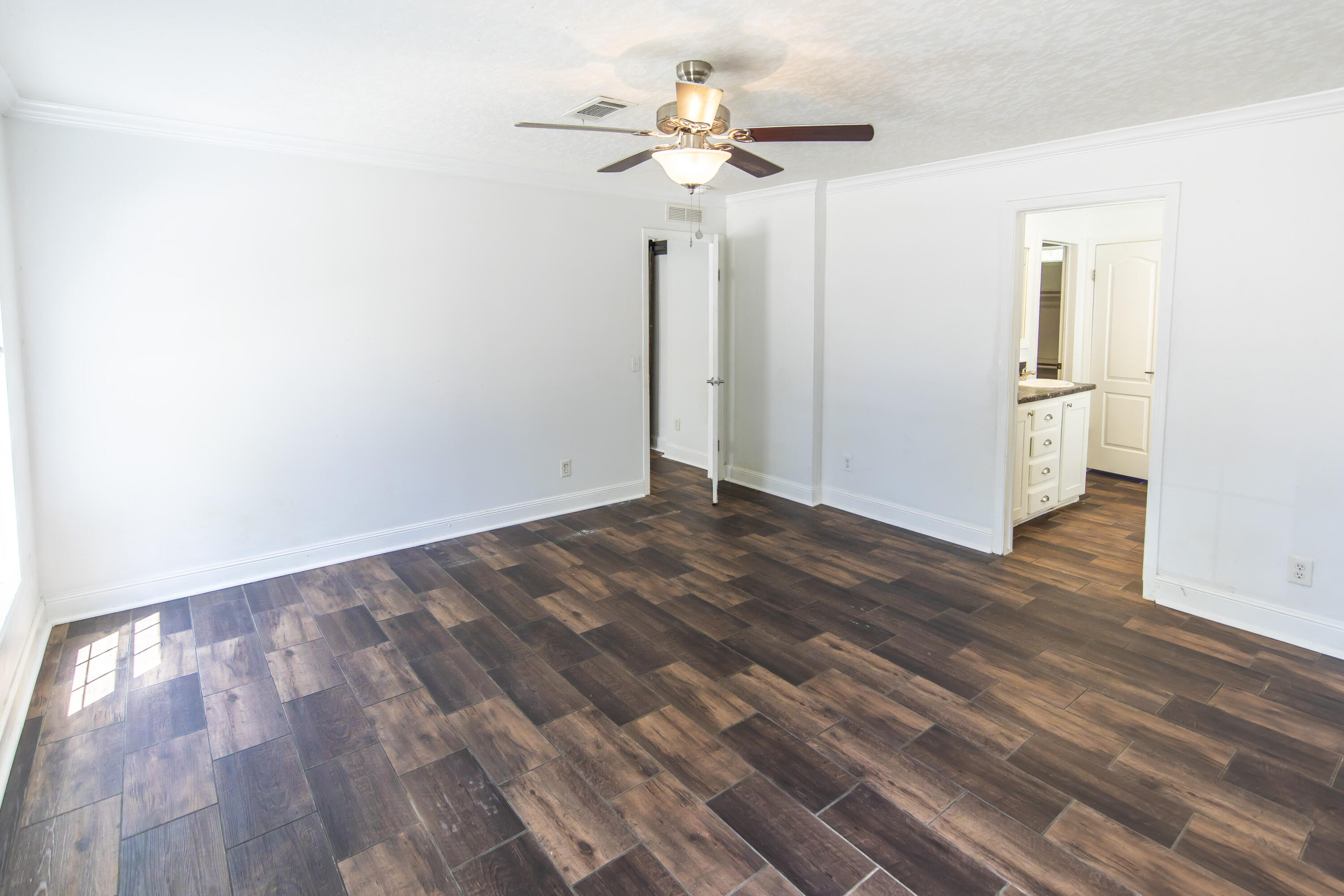 748 Phillips Drive Freeport, FL 32439 - Photo 22 of 50 a view of a room with wooden floor and a ceiling fan