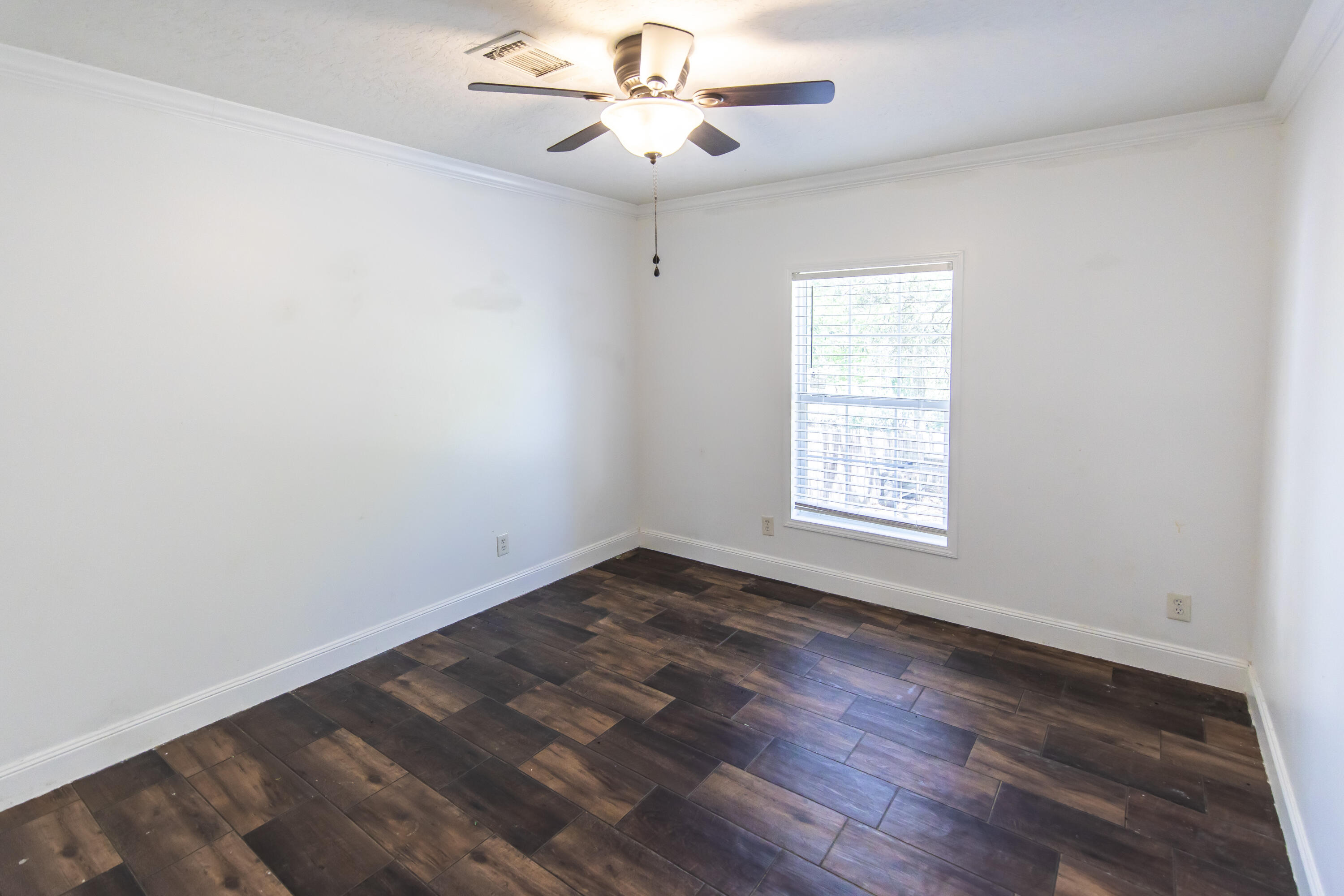 748 Phillips Drive Freeport, FL 32439 - Photo 29 of 50 an empty room with wooden floor chandelier fan and windows