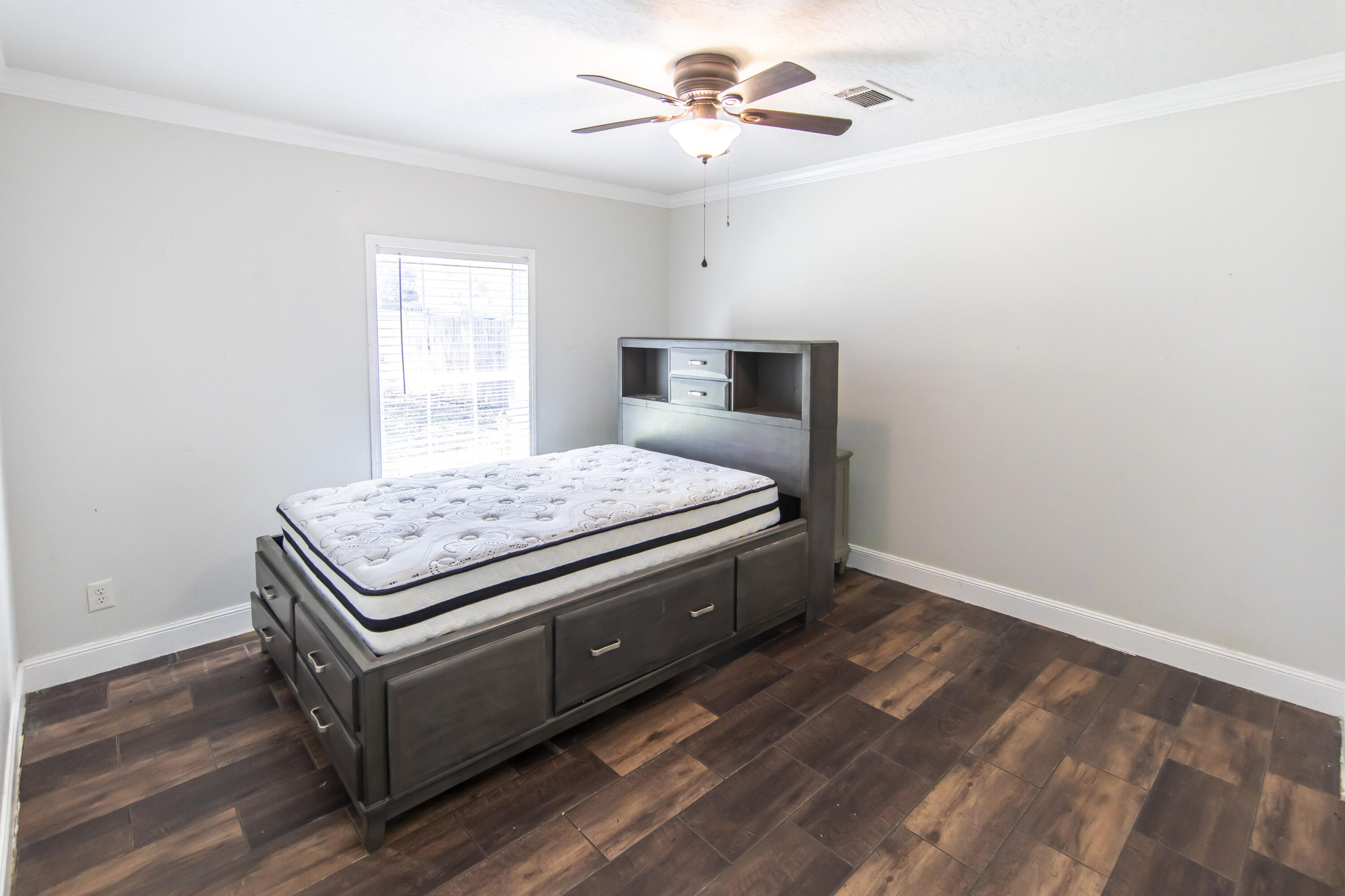 748 Phillips Drive Freeport, FL 32439 - Photo 33 of 50 a bedroom with a bed and a chandelier