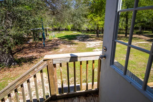 a view of a swimming pool with a patio and a yard