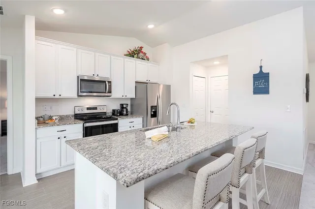 a kitchen with kitchen island granite countertop a sink stove and refrigerator