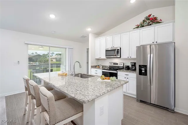 a kitchen with granite countertop kitchen island cabinets stainless steel appliances and a counter top space