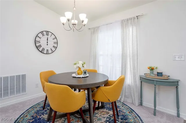 a view of a dining room with furniture and a chandelier