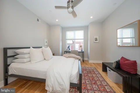 a bedroom with a bed and wooden floor