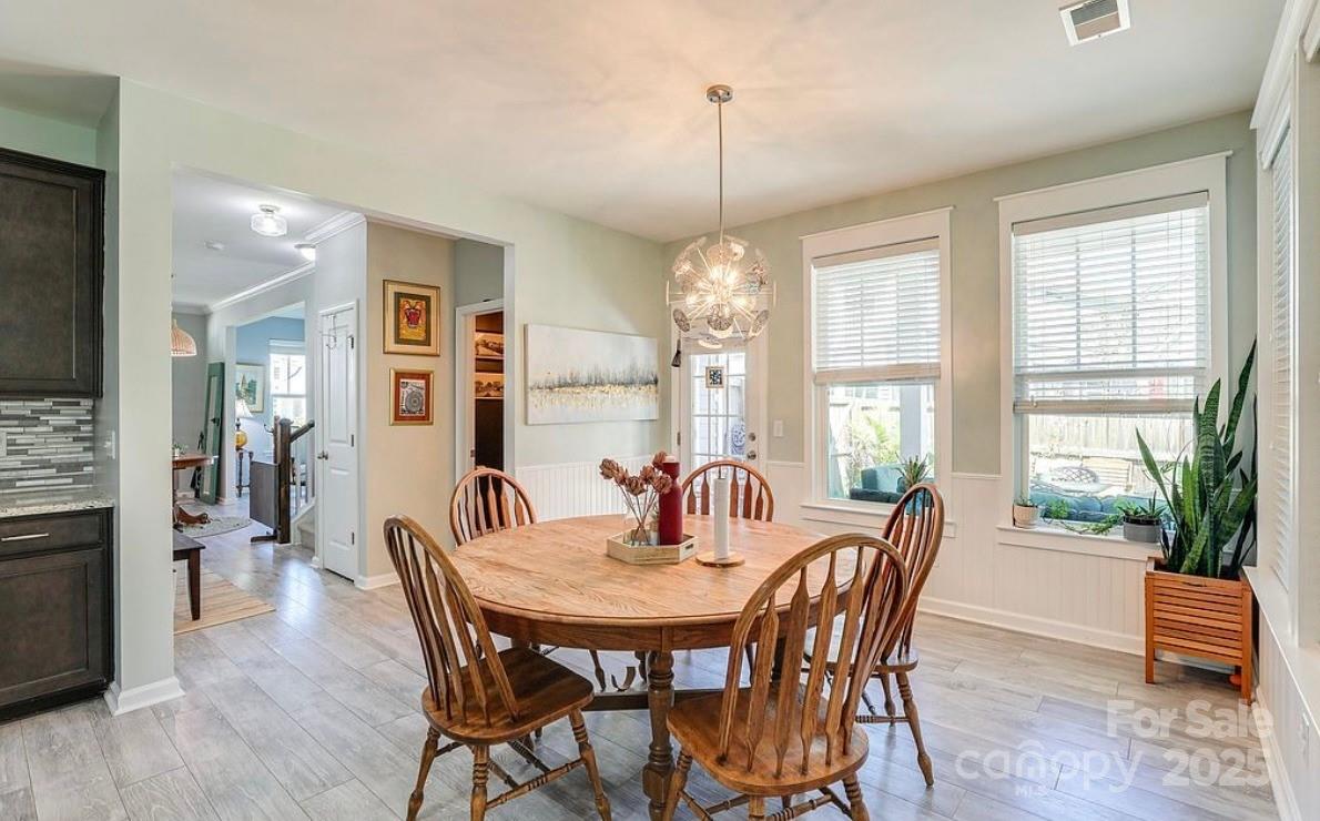 411 Stonefield Circle Moncks Corner, SC 29461 - Photo 11 of 42 a dining room with furniture a chandelier and wooden floor