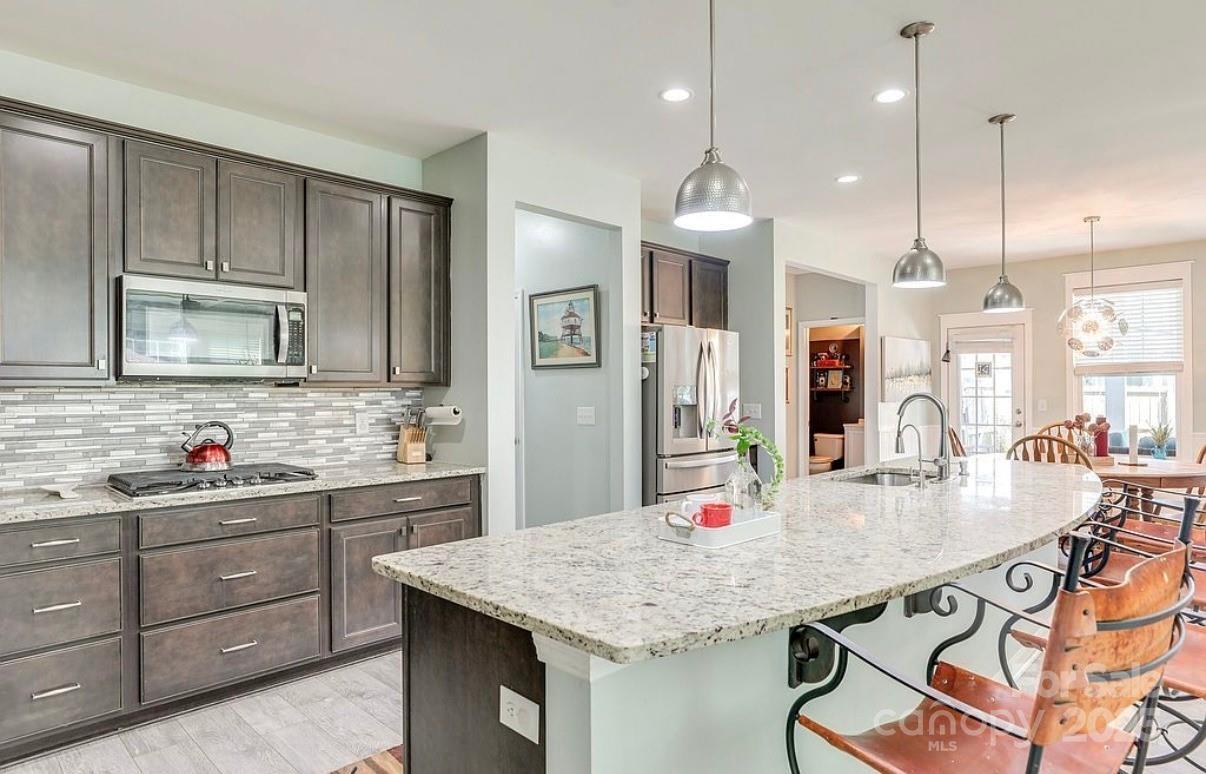 411 Stonefield Circle Moncks Corner, SC 29461 - Photo 13 of 42 a kitchen with stainless steel appliances kitchen island granite countertop a sink a cabinets and wooden floor