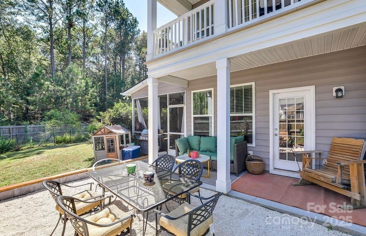 411 Stonefield Circle Moncks Corner, SC 29461 - Photo 5 of 42 a view of a patio with couches dining table and chairs with wooden floor and fence
