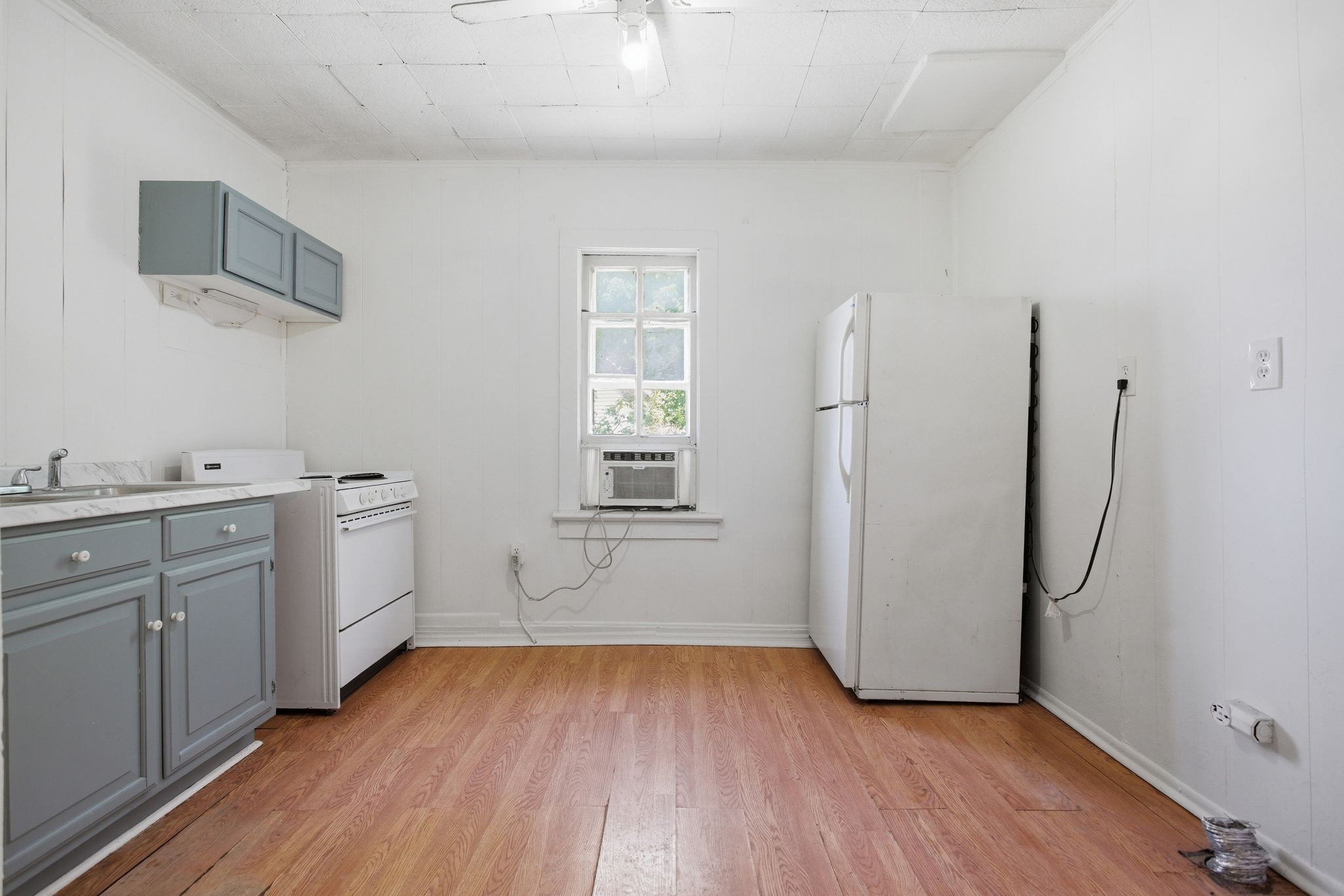433 Jones Street Pulaski, TN 38478 - Photo 18 of 25 a view of a kitchen with white cabinets and wooden floor