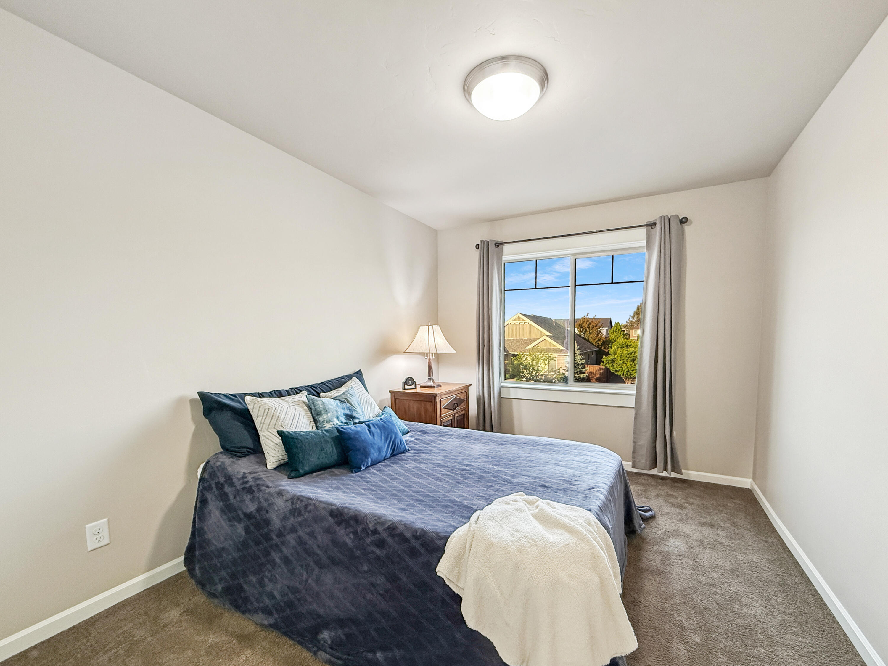 61072 Manhae Loop Bend, OR 97702 - Photo 33 of 63 a bed sitting in a bedroom next to a window